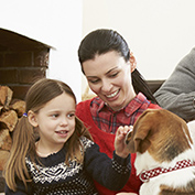 niña y su mama jugando con un perro